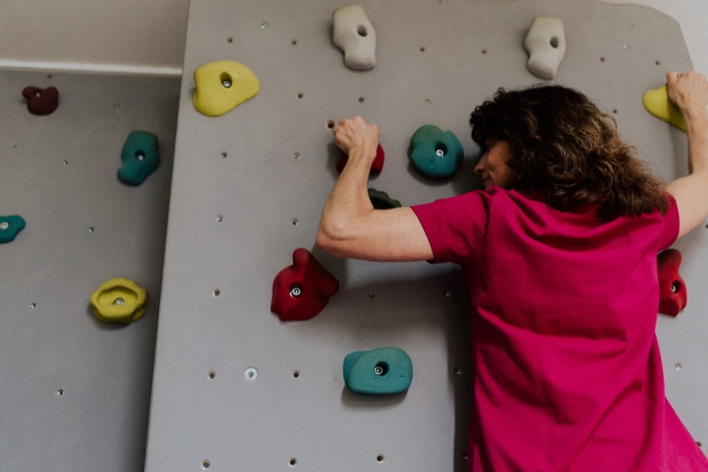 Therapeutin an der Kletterwand der Praxis